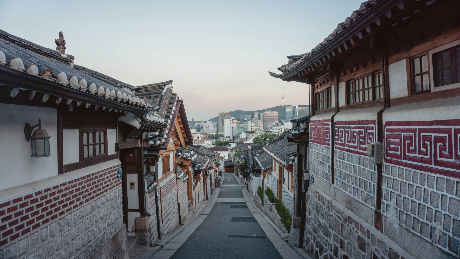 Steeg in Bukchon Hanok Village met traditionele Koreaanse huizen en N Seoul Tower op de achtergrond